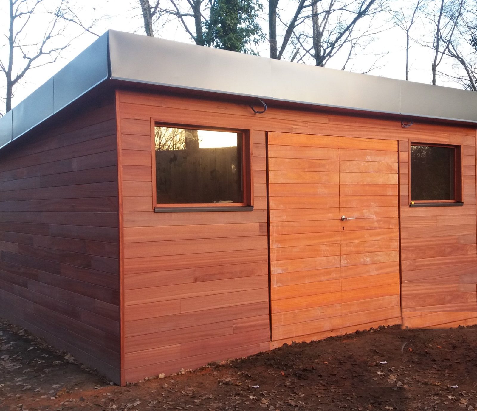Abri de jardin sur mesure en bois exotique, toit plat et fenêtres, bardage horizontal