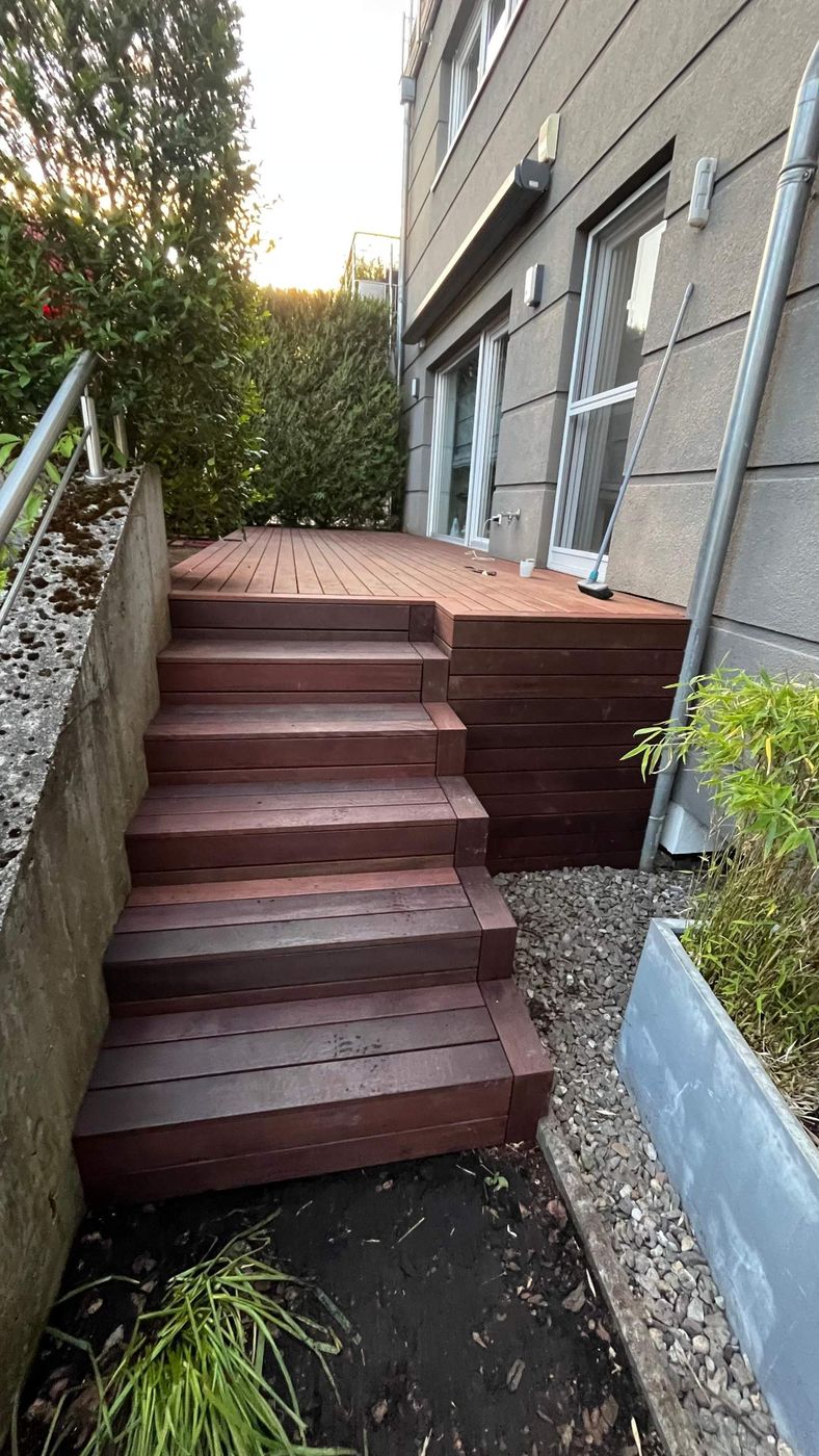 Escalier et terrasse surélevée en bois le long d'une façade
