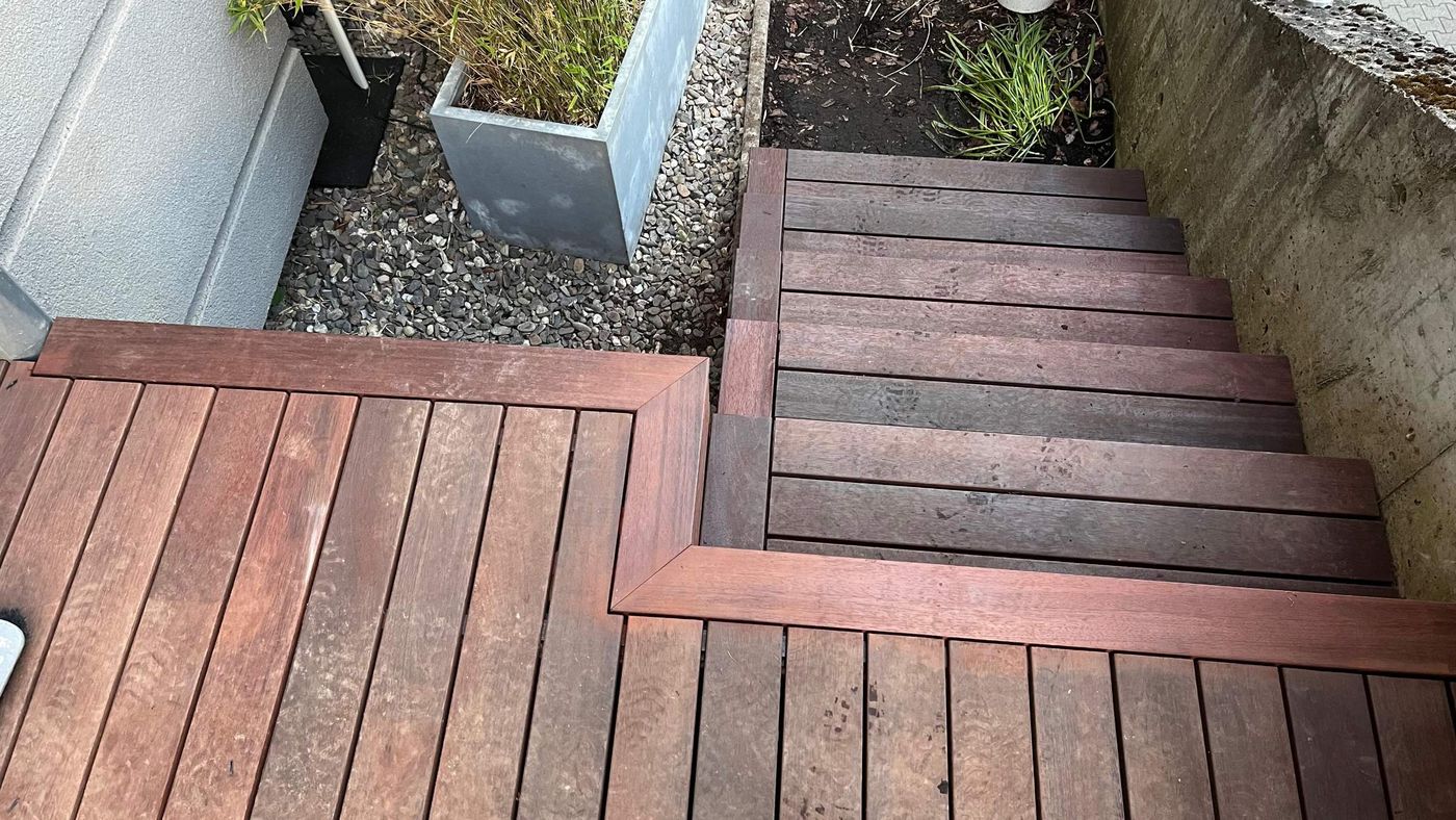 Escalier en bois vu du dessus, raccordé à la terrasse par une bordure en onglet
