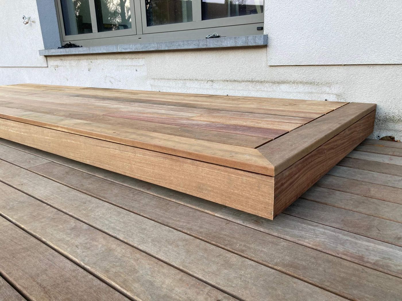 Marche ou banc en bois posé sur une terrasse, chants fermés