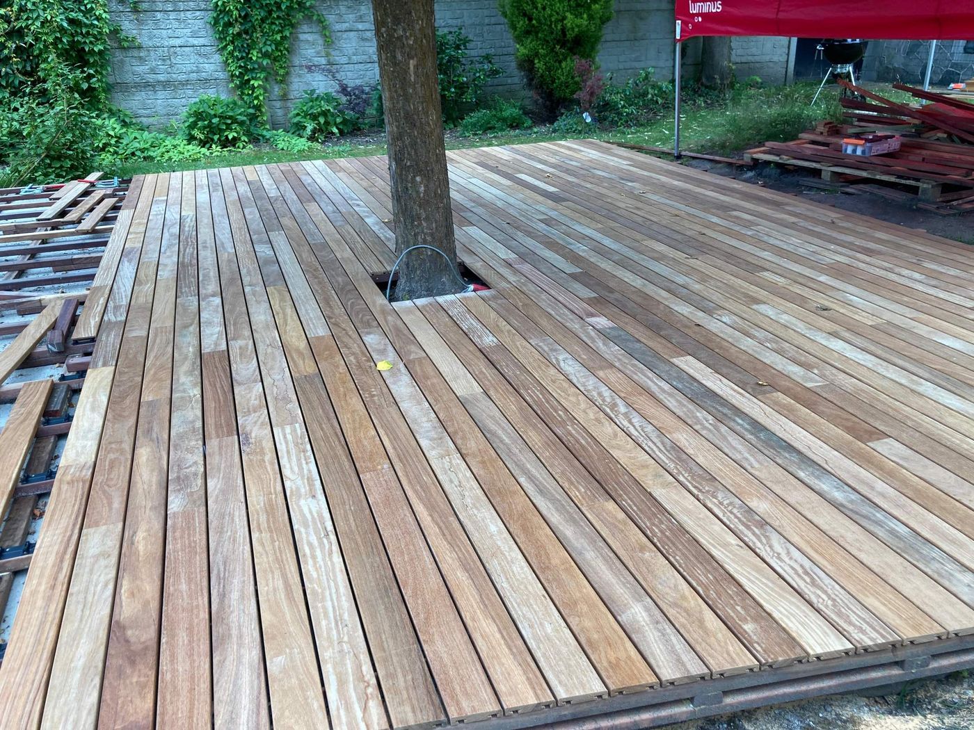 Terrasse en bois en cours de pose autour d'un arbre