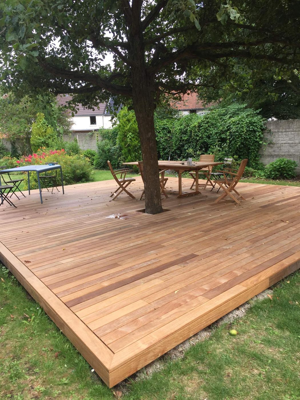 Terrasse en bois sous un arbre, avec table et chaises