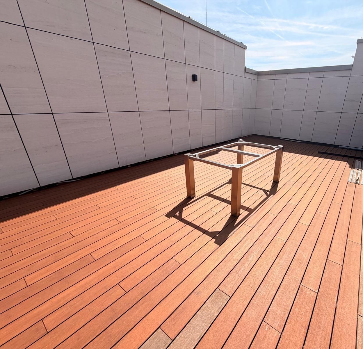 Toiture-terrasse en parquet de jardin VETEDY en bambou, au pied d'une façade en grands panneaux blancs