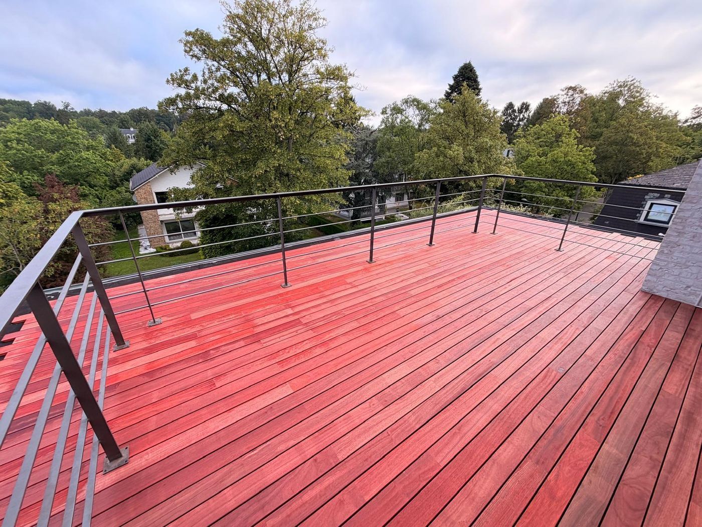 Toiture-terrasse en parquet de jardin VETEDY, padouk avec garde-corps en acier, vue sur les arbres