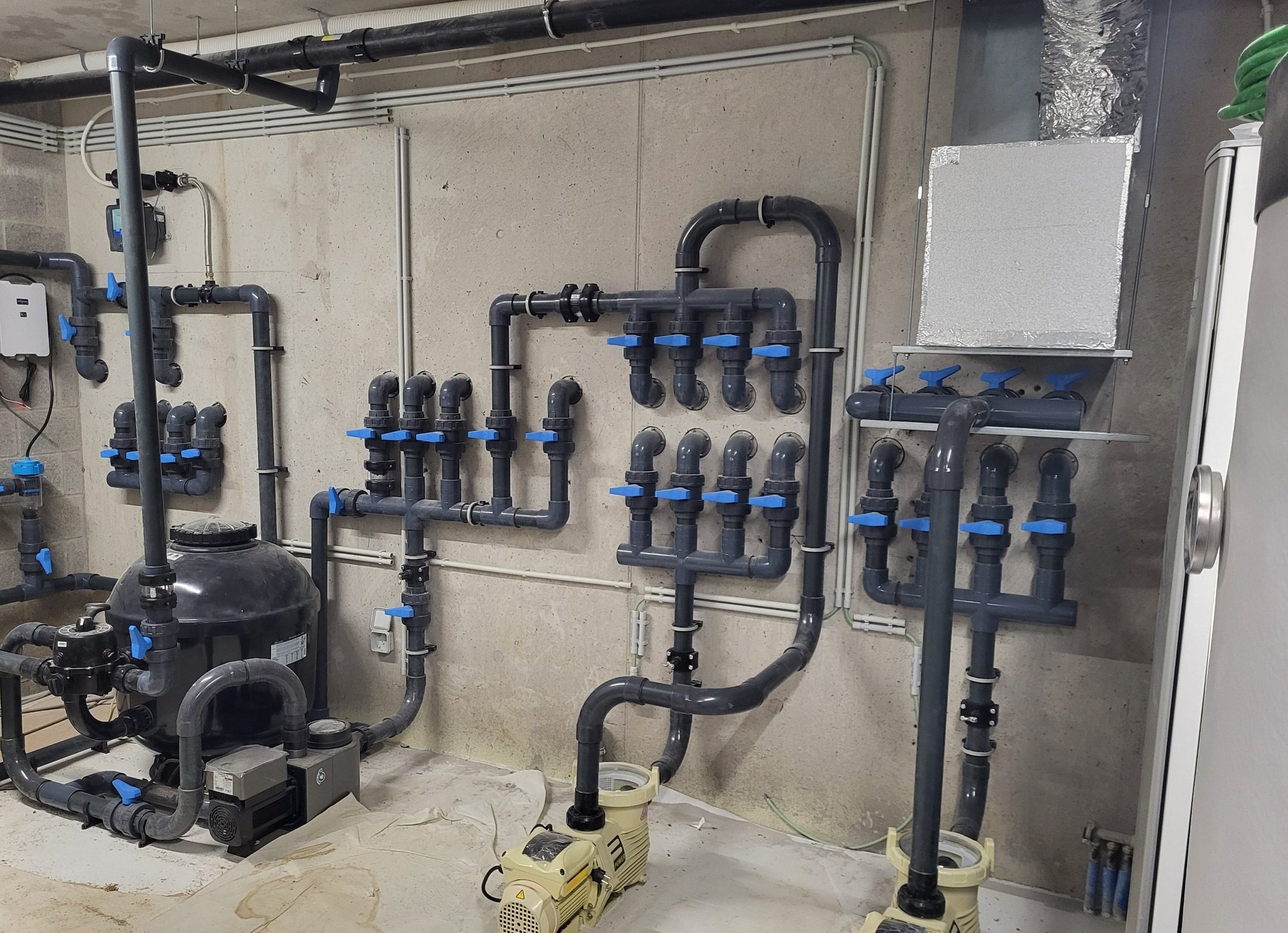 Local technique de la piscine à débordement d'Uccle : filtre, pompes, collecteurs et vannes